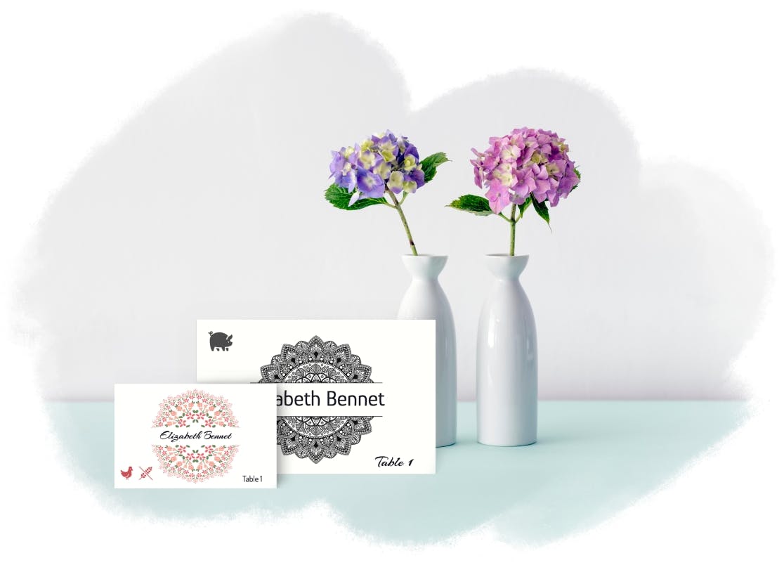 Virágos esküvői ültetőkártyák kézzel írt nevekkel, lila hortenziák mellett fehér vázákban az esküvői asztaldíszítéshez.