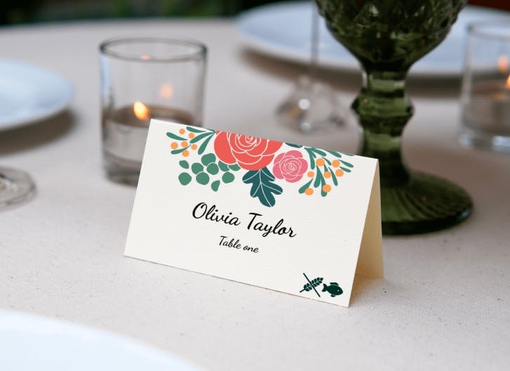 Elegant place card with floral design featuring roses for Olivia Taylor at table one, set on a sophisticated dining table.